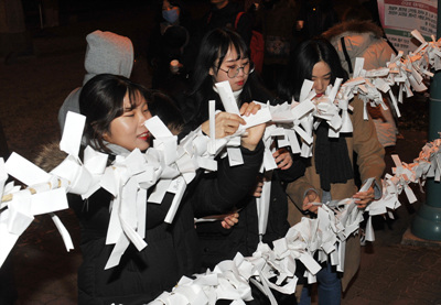 지난달 31일 울산대공원 동문일원에서 열린 '아듀! 2017 송년제야행사'를 찾은 시민들이 새해 소망을 적은 소망지를 달고 있다.