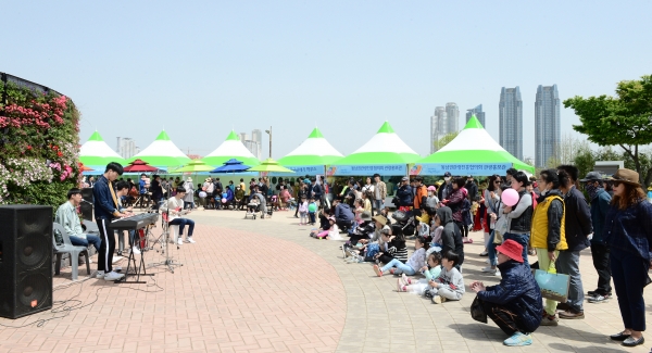 정원열린마당에서 버스킹 공연을 즐기고 있는 많은 나들이객들.
