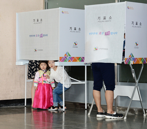 부모님과 함께 투표소를 찾은 어린이들이 투표소를 신기한 듯 보고 있다.