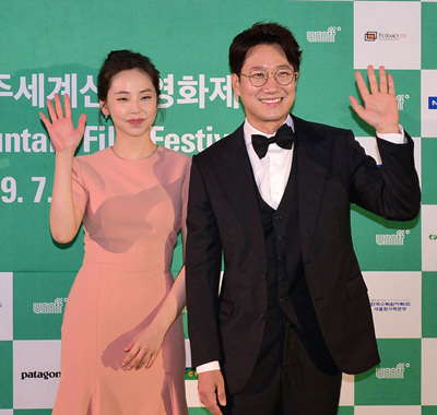 개막식 사회를 맡은 배우 안소희와 방송인 조우종이 그린 카펫 행사에 참석해 포즈를 취하고 있다.