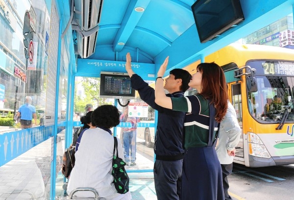 남구가 여름철 버스이용객들의 편의를 위해 버스승강장에 에어커튼을 설치한 가운데 23일 버스승강장에서 시민들이 에어커튼을 사용하고 있다.