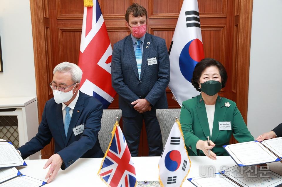 13일 주한 영국대사관에서 열린 국제 기후리스크 관리 모형 '프론티어 -1.5D' 개발을 위한 업무 협약식에서 김은미 이화여대 총장(오른쪽)과 김준 SK이노베이션 대표가 협약서에 서명하고 있다. SK이노 제공