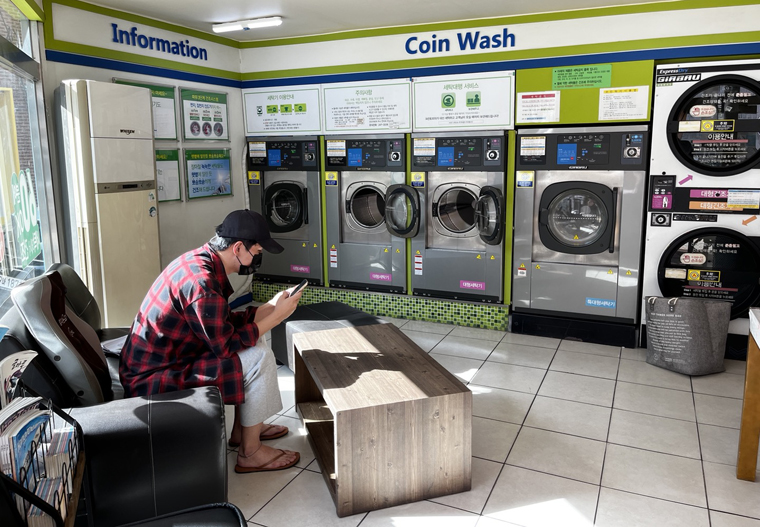 지난 18일 공정거래위원회가 '무인세탁소 표준약관'을 제정한 가운데 20일 울산지역에서 한 시민이 무인세탁소에서 세탁물을 기다리고 있다.