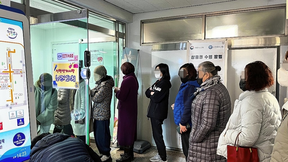 설날 연휴를 앞둔 19일 울산 남구 신정시장에 수산물을 구매한 시민들이 온누리 상품권 교환을 위해 줄을 서 있다.