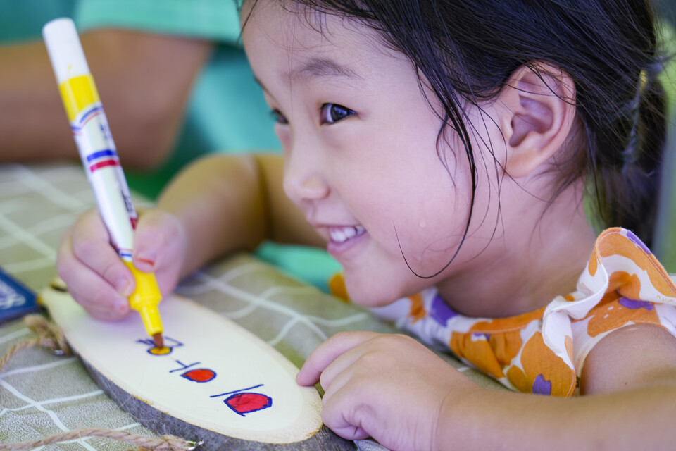 우드 갤리그라피 체험 부스에서 원목에 자신의 이름을 쓰고 색을 입히고 있는 어린이가 옅은 미소를 띄고 있다. 김동균기자 justgo999@ulsanpress.net