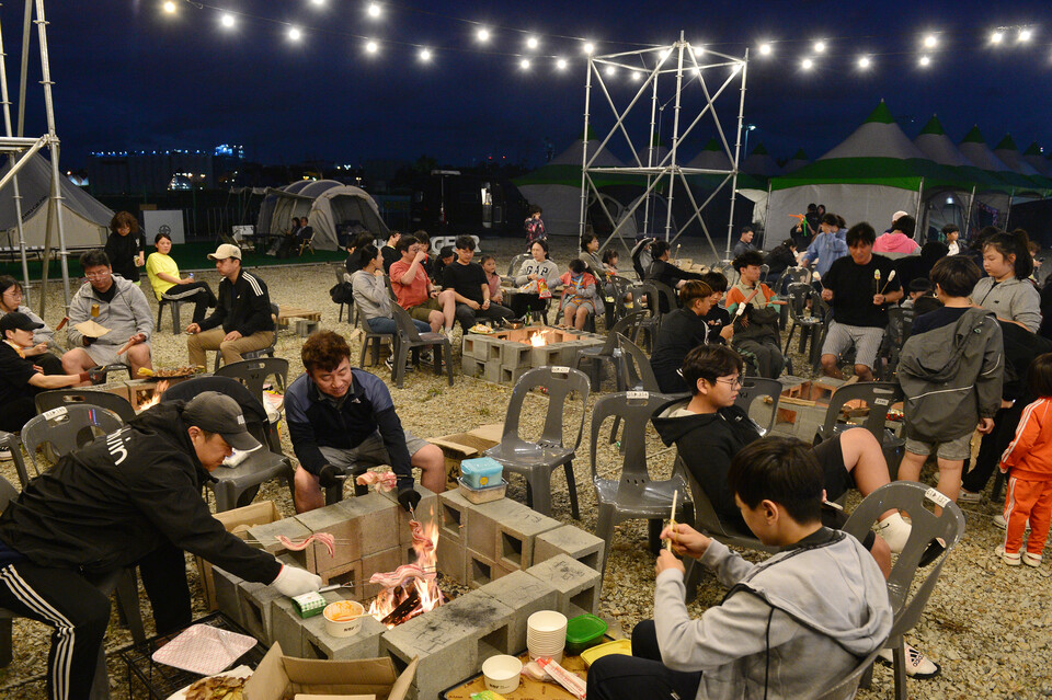 '캠프파이어존'에 삼삼오오 모여 불멍과 맛있는 음식을 음미하며 공연을 즐기고 있는 참가자들.