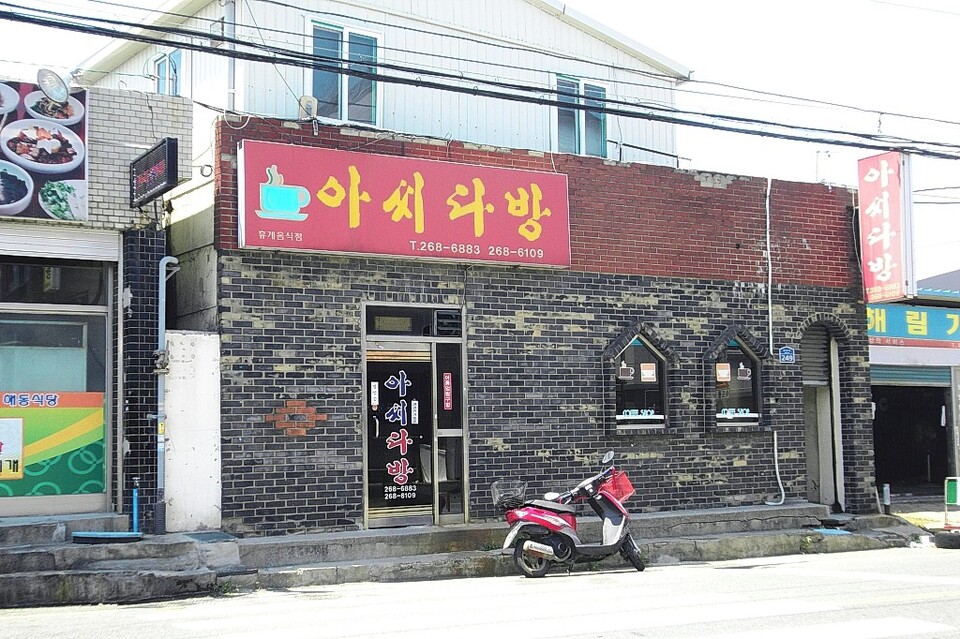 아씨다방 앞에 배달용 오토바이가 대기하고 있다.