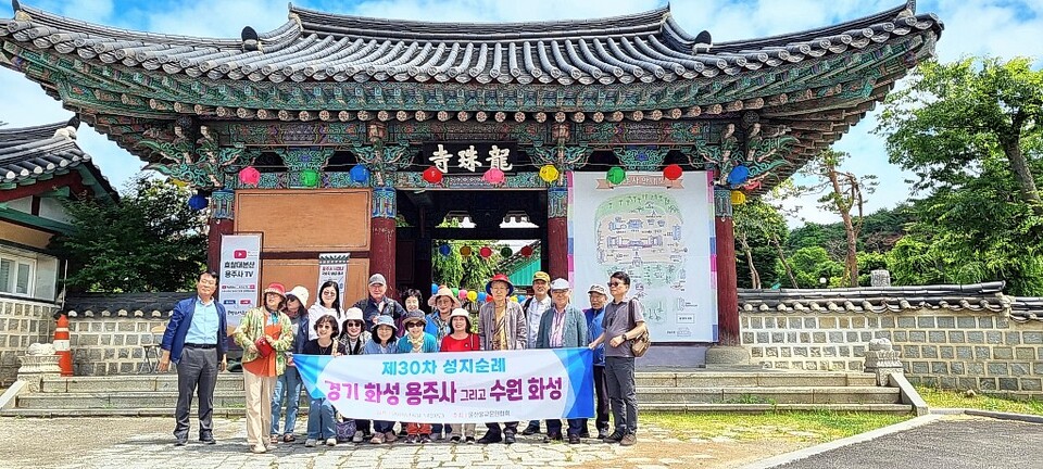 용주사 현판을 배경으로 울산불교문인협회 회원들이 기념사진을 촬영하고 있다.&nbsp;정은영 제공