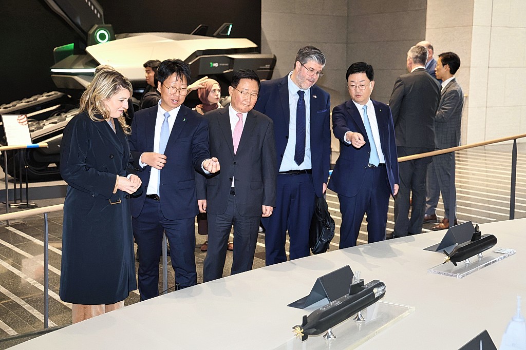 멜라니 졸리 캐나다 산업부 장관과 필립 라포튠 주한 캐나다 대사 일행이 HD현대 조석 부회장, HD현대중공업 주원호 사장과 함께 HD현대 글로벌R&D센터에서 미래형 선박·잠수함·호위함 등 함정 모형을 둘러보고 있다.  HD현대 제공